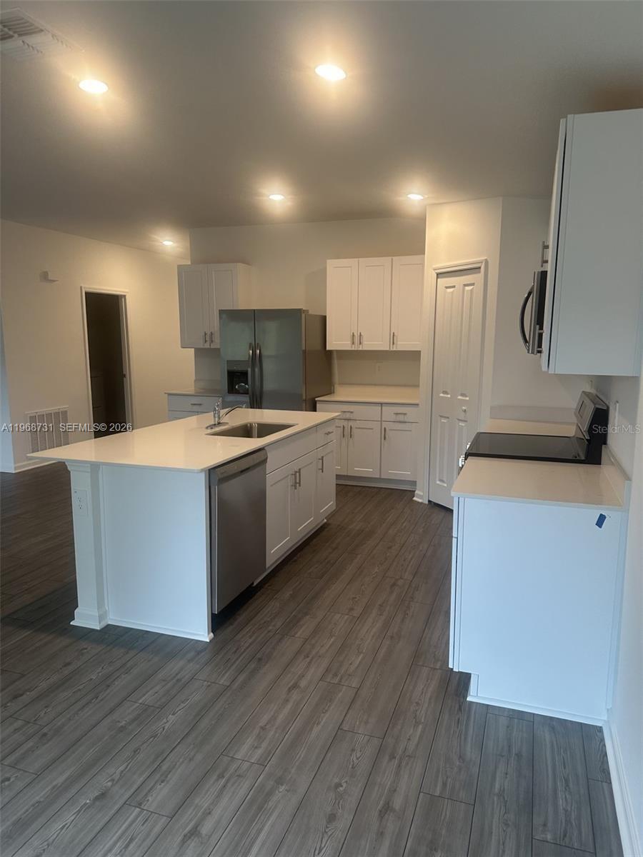 13110 Southwest 89th Street Dunnellon, FL 34432 - Photo 8 of 8 a kitchen with wooden floors and white appliances