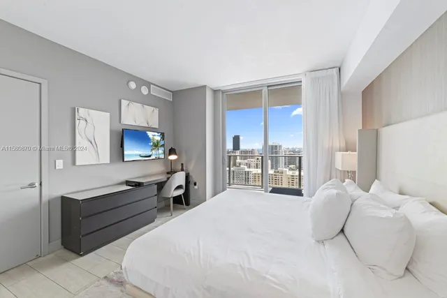 a living room with furniture a large window and a wooden floor