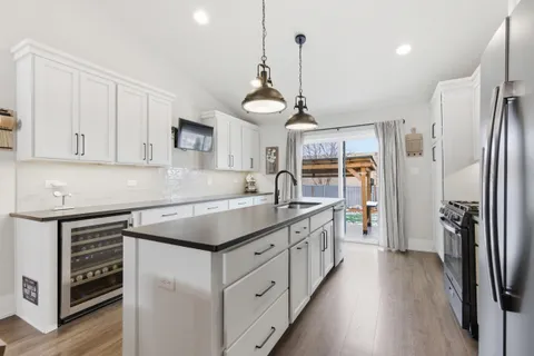 a kitchen with stainless steel appliances granite countertop a sink stove and refrigerator