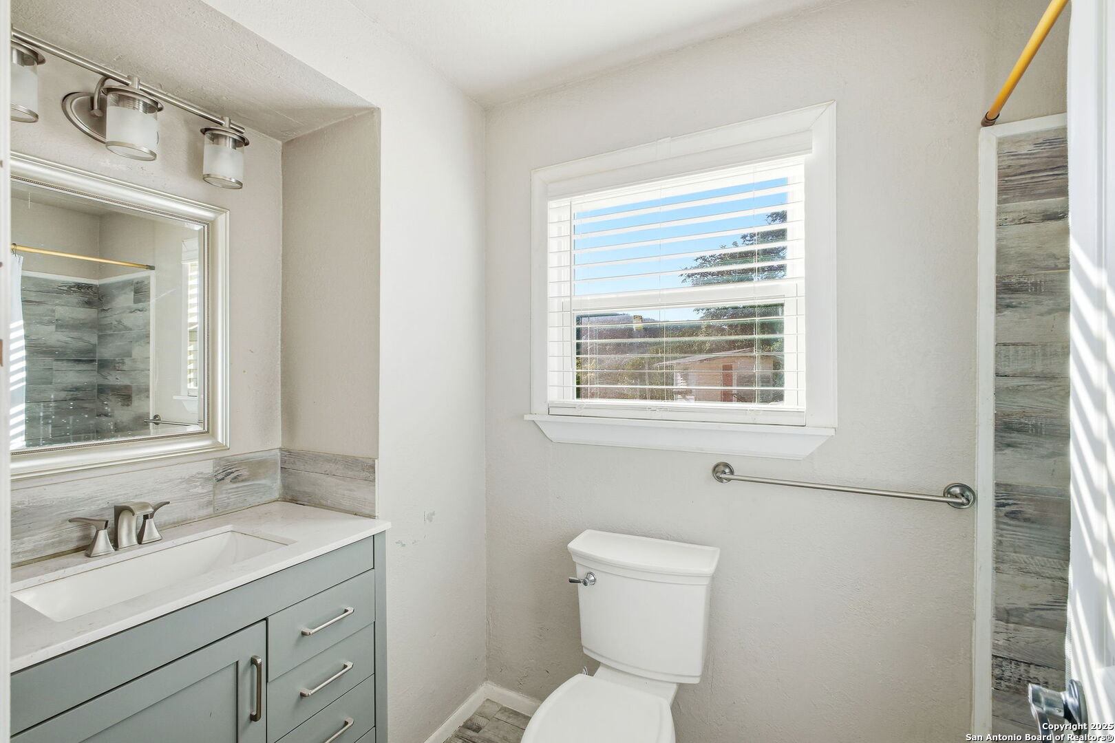 18668 Bandera Road Helotes, TX 78023 - Photo 46 of 52 a bathroom with a toilet sink vanity and mirror