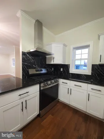 a kitchen with granite countertop white cabinets and black appliances