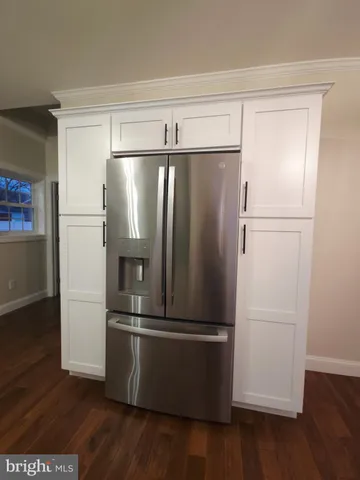 a metallic refrigerator freezer sitting in a kitchen