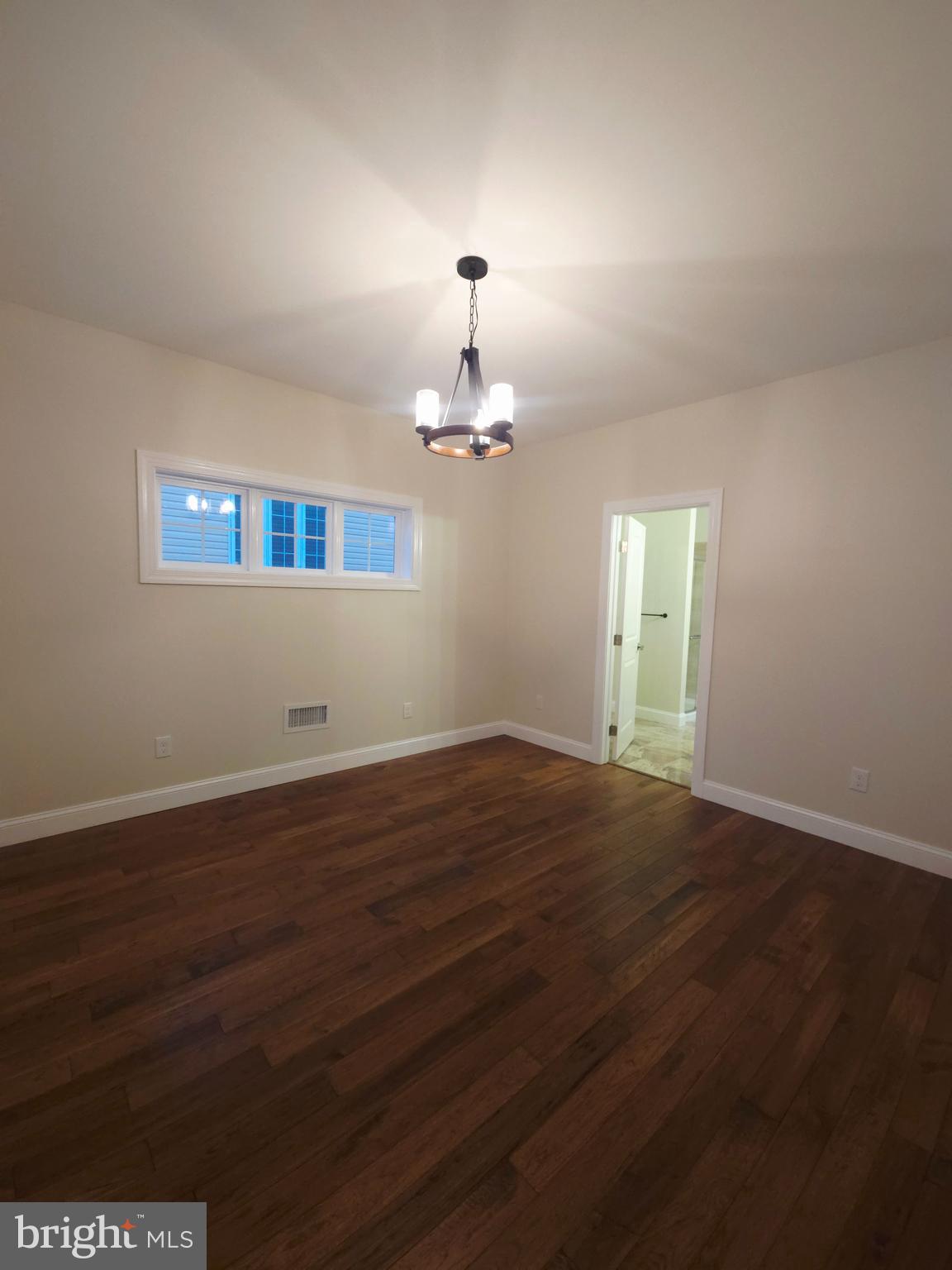 1015 Chambers Street Harrisburg, PA 17113 - Photo 8 of 23 an empty room with wooden floor chandelier and windows
