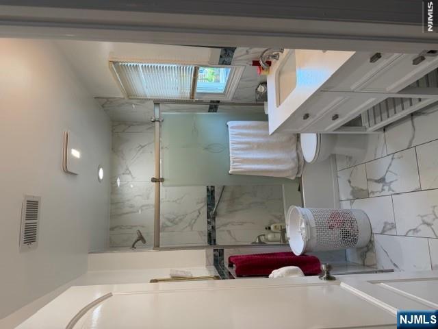 177 Maple Street Fairview, NJ 07022 - Photo 8 of 24 a bathroom with a sink a toilet and a mirror