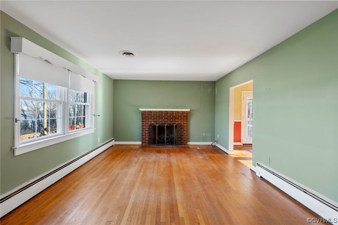 406 Riverside Avenue Hopewell, VA 23860 - Photo 6 of 38 a view of an empty room with window wooden floor and fire place