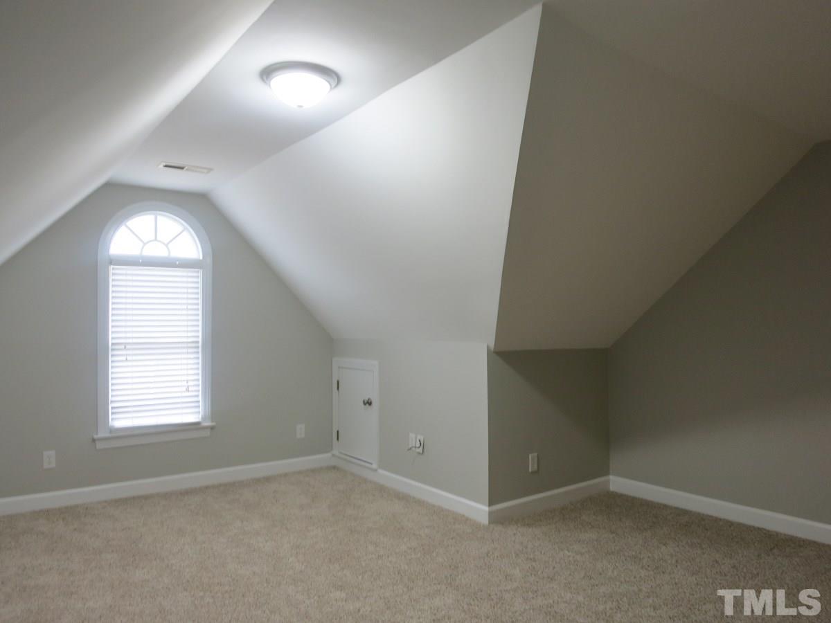 9305 Dawnshire Road Raleigh, NC 27615 - Photo 13 of 25 an empty room with a window and wooden floor