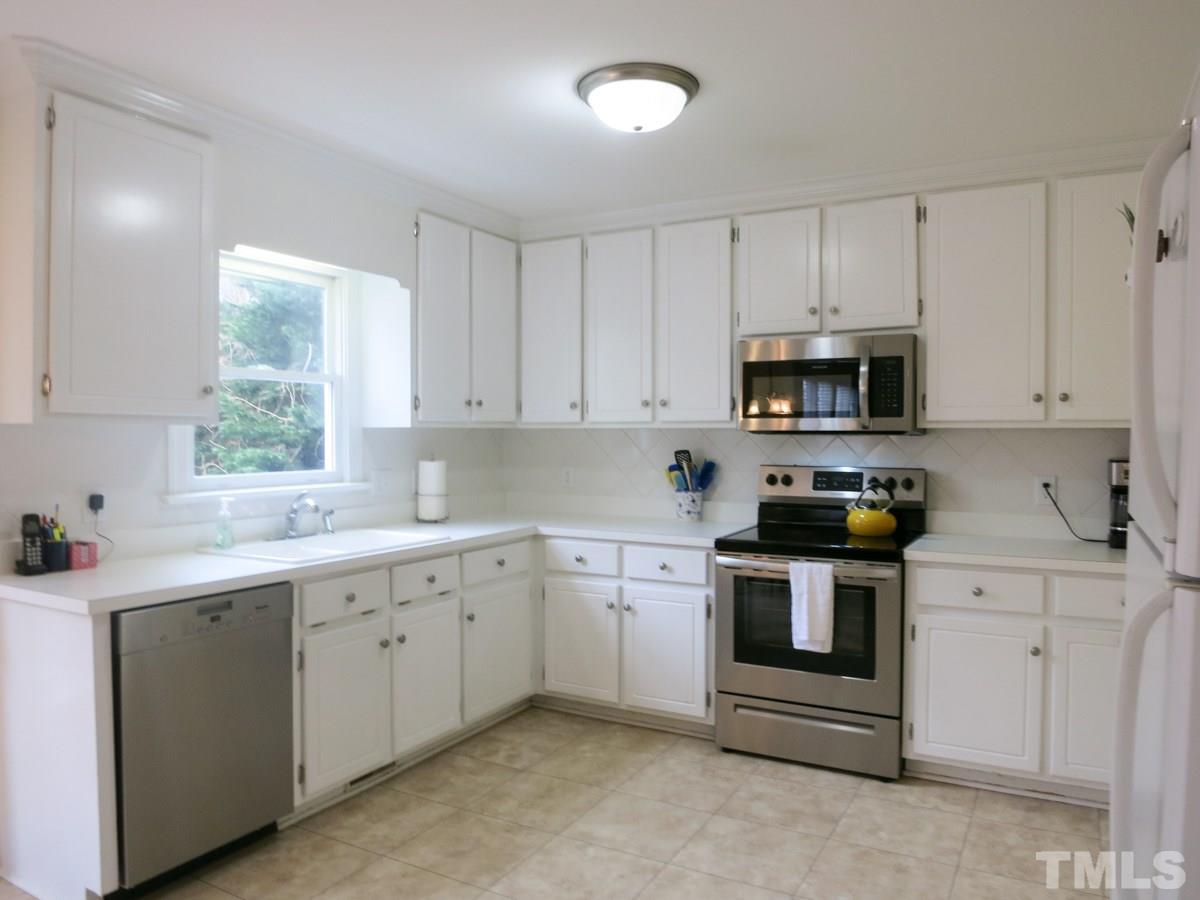 9305 Dawnshire Road Raleigh, NC 27615 - Photo 10 of 25 a kitchen with cabinets appliances a sink and a window