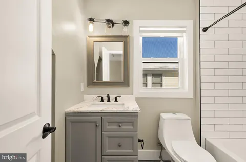 a bathroom with a toilet sink and mirror