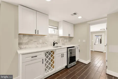 a kitchen with stainless steel appliances white cabinets and a stove top oven