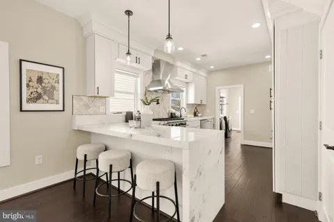 a large kitchen with kitchen island a dining table chairs sink and cabinets