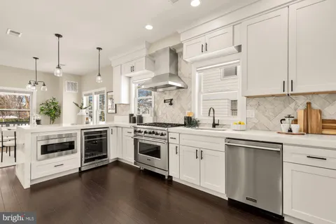 a kitchen with white cabinets stainless steel appliances and a window