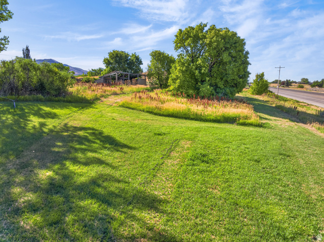 4380 Main Street Logan, UT 84321 - Photo 61 of 74 Expansive grassy area with mature trees and a distant mountain backdrop