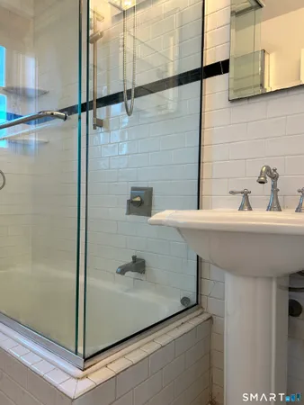 an empty room with wooden floor cabinet and windows