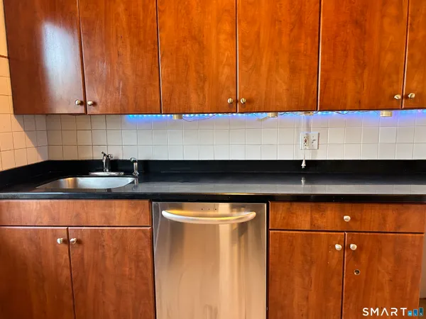 a kitchen with stainless steel appliances granite countertop a sink window and cabinets