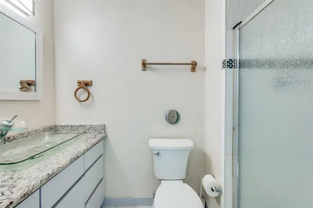 a bathroom with a granite countertop sink toilet and shower