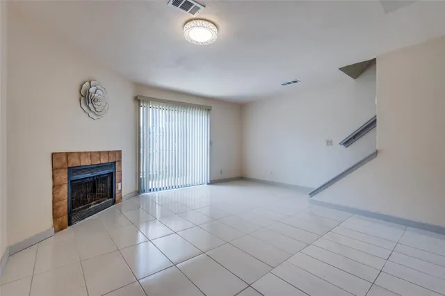 an empty room with windows and fireplace
