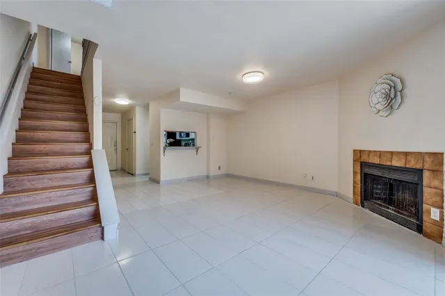 a view of an empty room with stairs and a fireplace