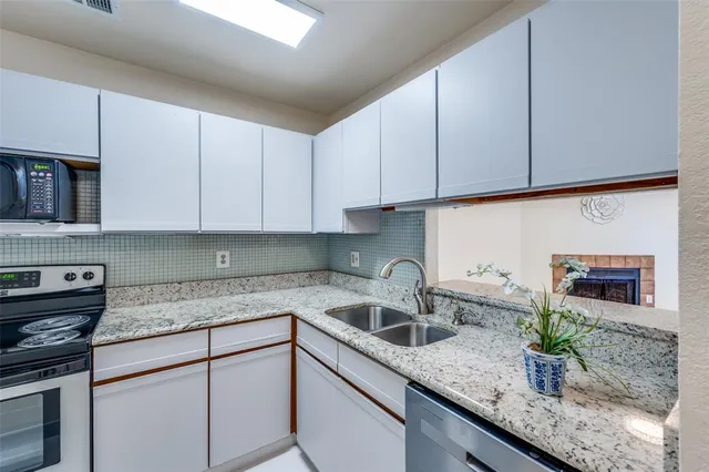 a kitchen with stainless steel appliances granite countertop a sink a stove and cabinets
