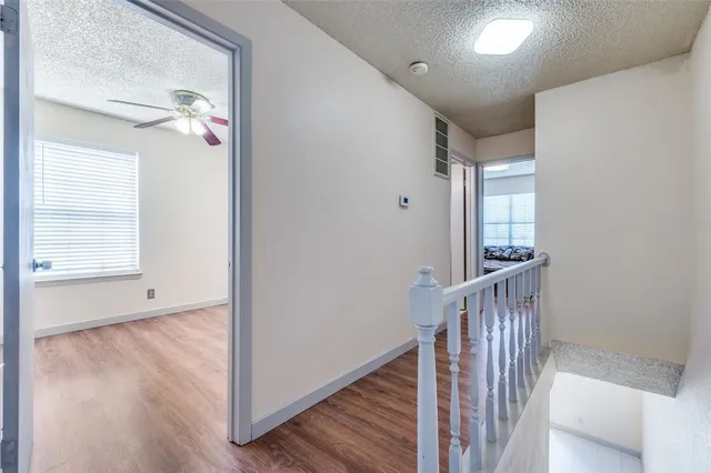 a view of a hallway with wooden floor and staircase