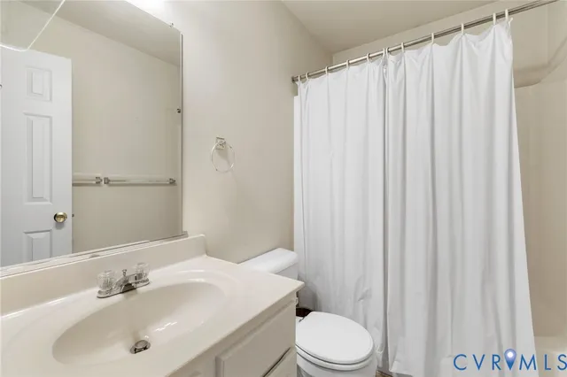 a bathroom with a sink a toilet and shower curtain