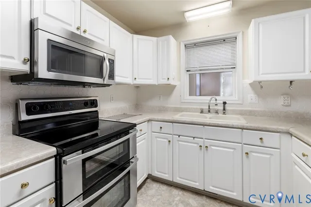 a kitchen with white cabinets and stainless steel appliances