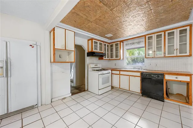 a kitchen with a stove sink and cabinets
