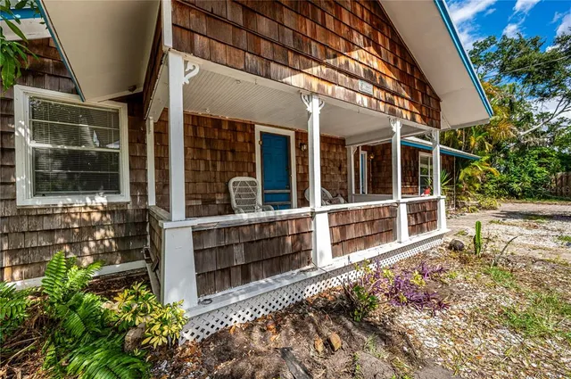 a view of a house with a large window and wooden fence