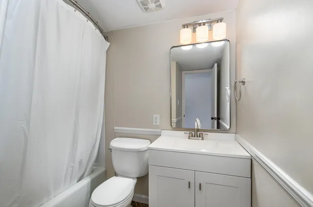 a bathroom with a toilet sink and mirror