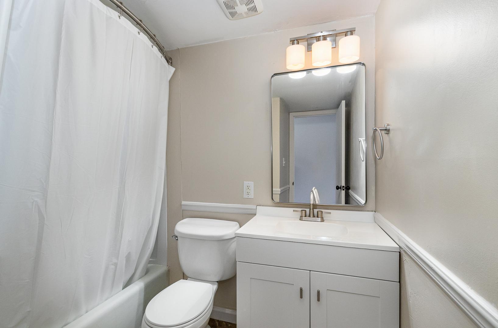 1130 Schaub Drive, Unit C Raleigh, NC 27606 - Photo 15 of 25 a bathroom with a toilet sink and mirror