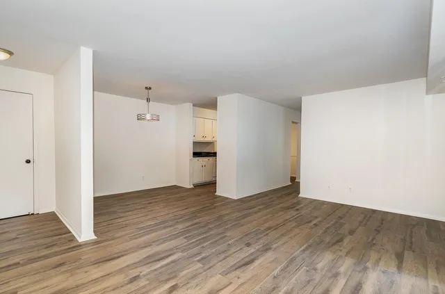 a view of an empty room with wooden floor