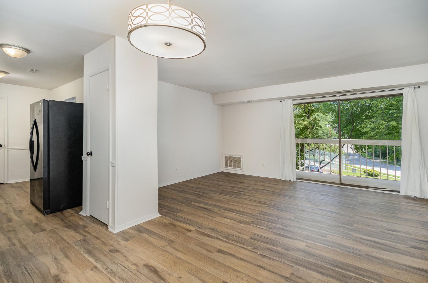 1130 Schaub Drive, Unit C Raleigh, NC 27606 - Photo 6 of 25 a view of an empty room with wooden floor and a window