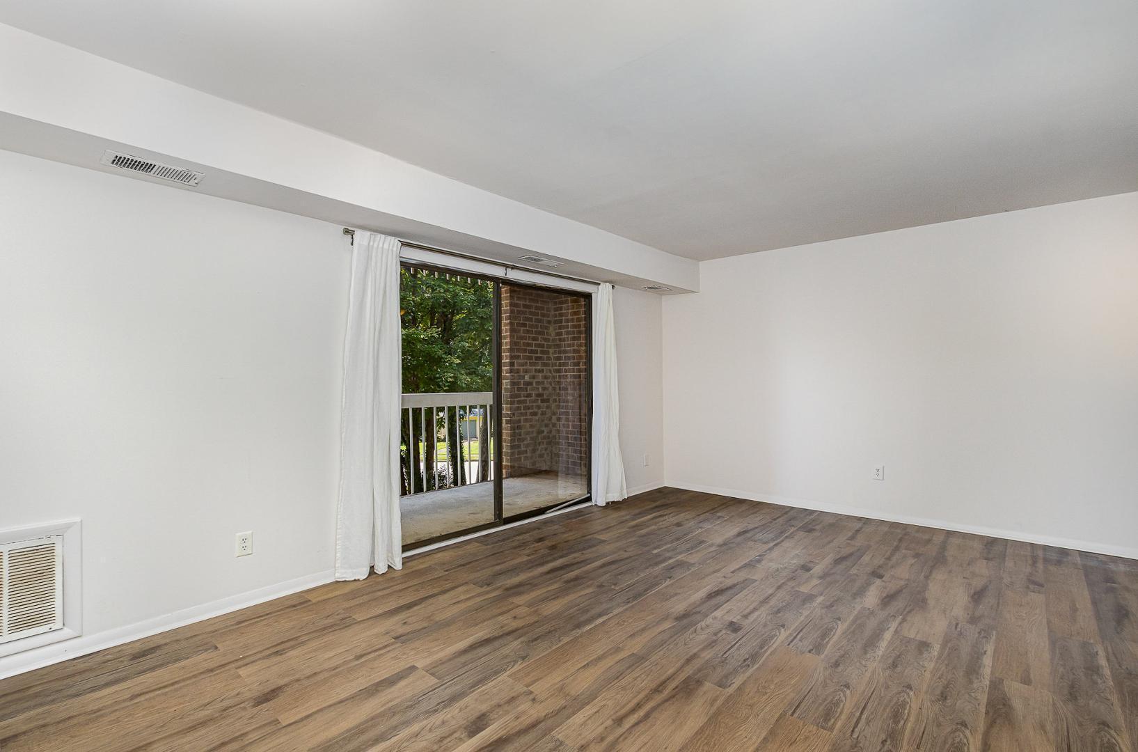 1130 Schaub Drive, Unit C Raleigh, NC 27606 - Photo 7 of 25 wooden floor in an empty room with a window