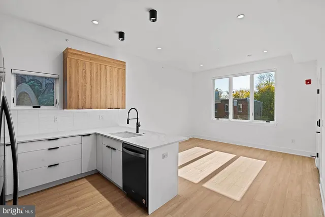 a kitchen with a sink cabinets appliances and a window