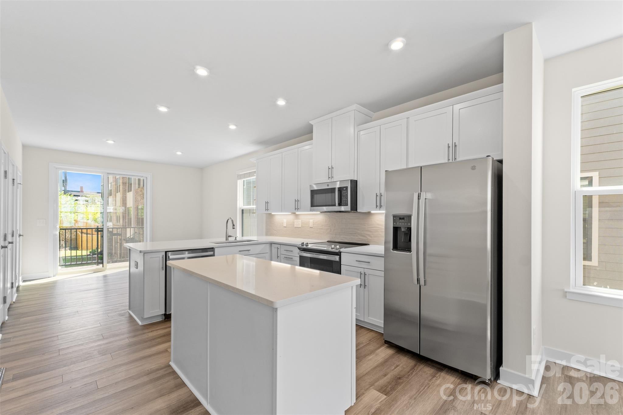 3645 South Tryon Street Charlotte, NC 28217 - Photo 12 of 45 a kitchen with stainless steel appliances a refrigerator a stove top oven and wooden floors