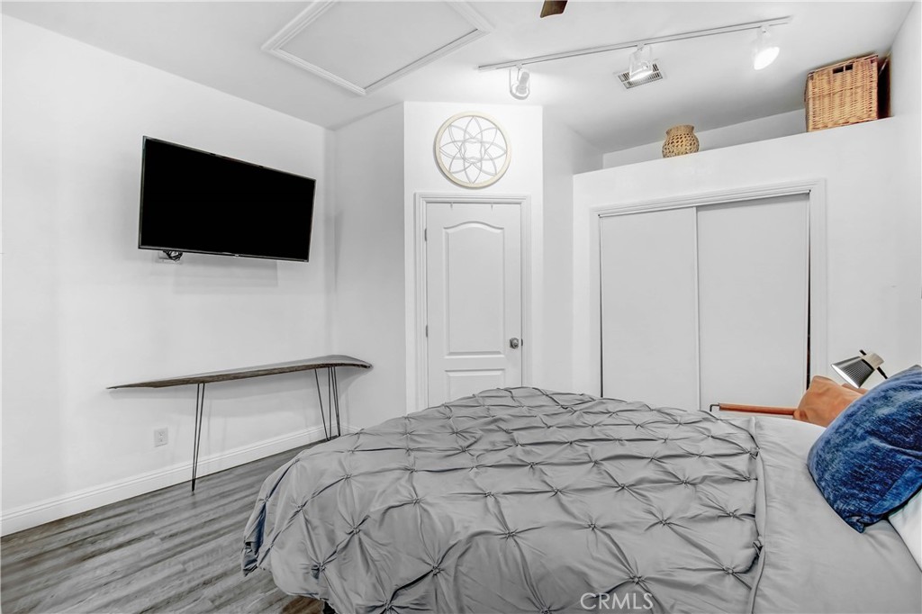 9732 Belmont Drive Riverside, CA 92503 - Photo 15 of 20 a bedroom with a bed a mirror and a flat tv screen on the table