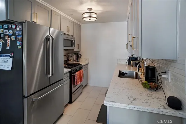 a kitchen with stainless steel appliances granite countertop a refrigerator and a sink