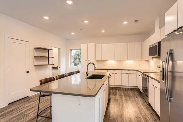 a kitchen with granite countertop a table chairs microwave and cabinets