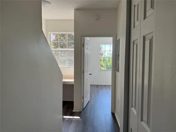 a view of a hallway with wooden floor and stairs