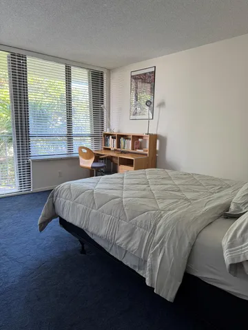 a bedroom with a bed and glass window