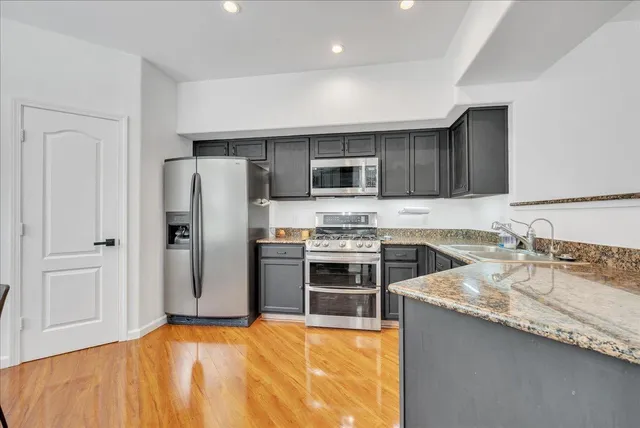 a kitchen with granite countertop a refrigerator stove and kitchen island