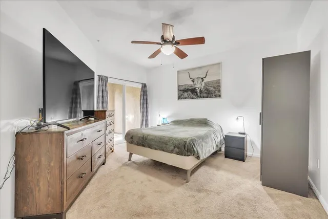 a spacious bedroom with a large bed and a chandelier