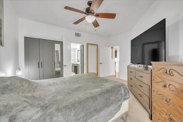 a spacious bedroom with a bed and a chandelier