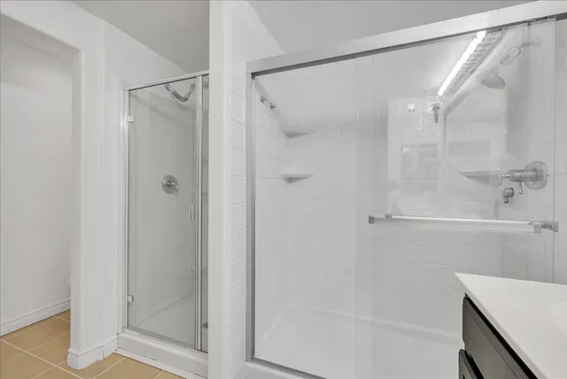 a bathroom with a glass shower door and a sink