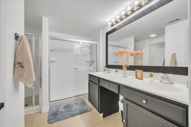 a bathroom with a double vanity sink a mirror and shower
