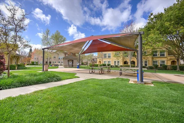 a patio with a table and chairs under an umbrella
