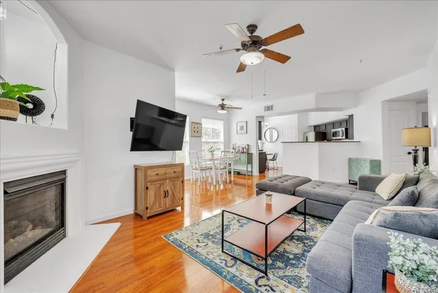 a living room with furniture a flat screen tv and kitchen view