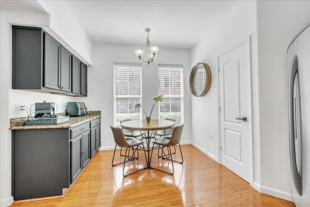 a dining hall with stainless steel appliances granite countertop a stove top oven a sink dishwasher with a dining table and chairs