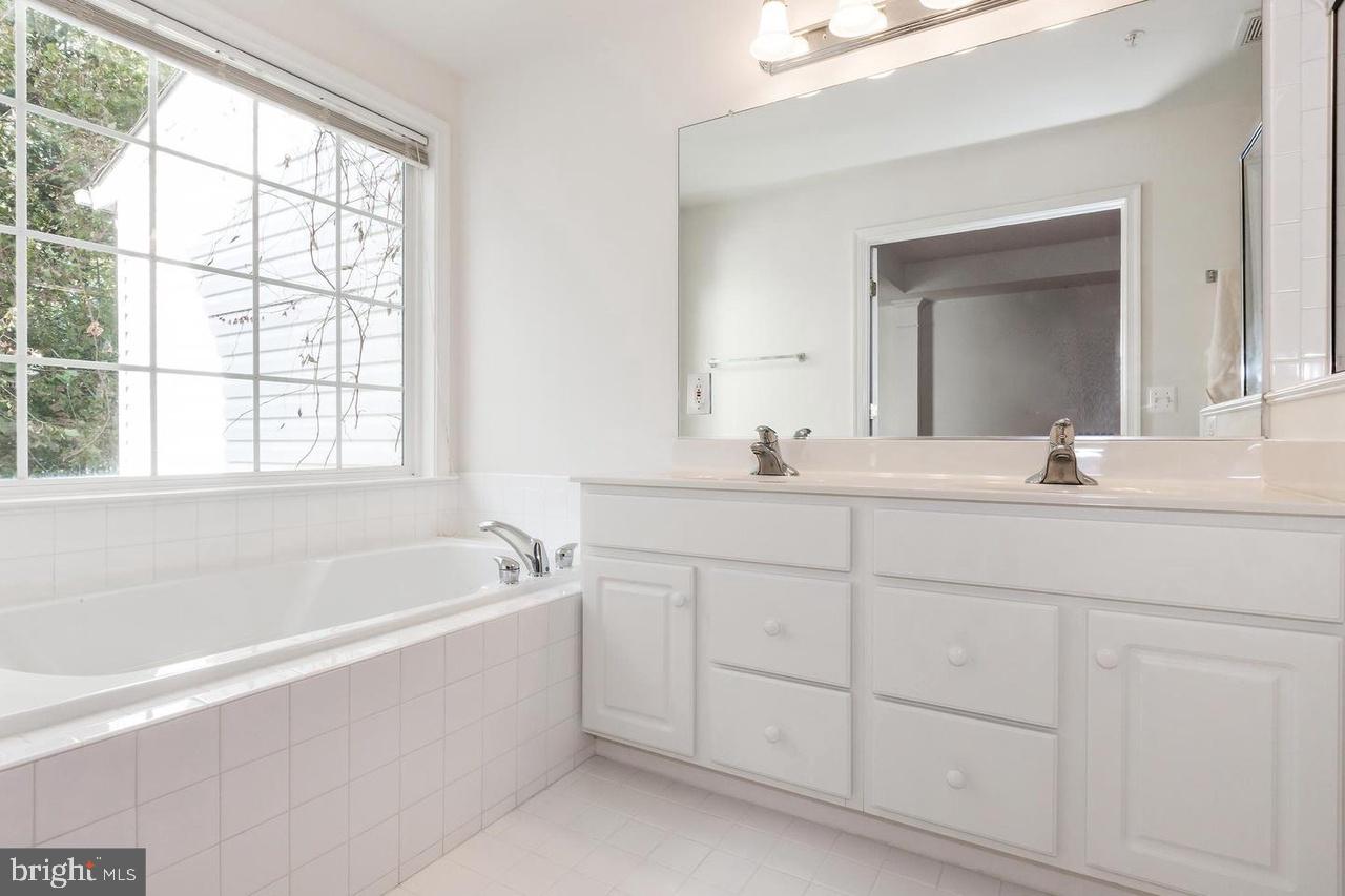 13953 Lullaby Road Germantown, MD 20874 - Photo 12 of 26 a bathroom with a bathtub a sink a vanity and a window