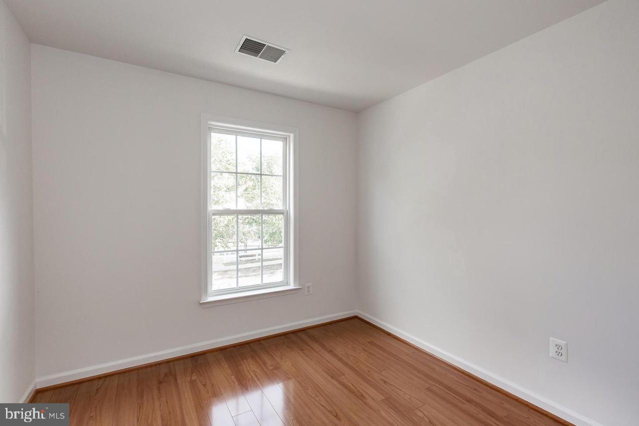 13953 Lullaby Road Germantown, MD 20874 - Photo 15 of 26 a view of an empty room with wooden floor and a window