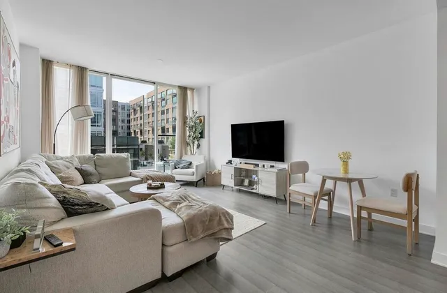a living room with furniture wooden floor and a flat screen tv